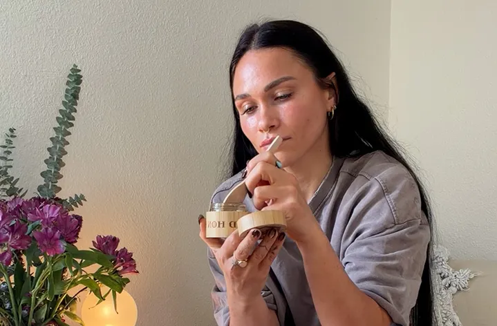 A woman tasting a spoon of Real Mad Honey