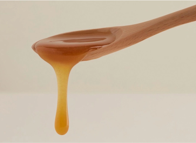 A spoon dripping Real Mad Honey